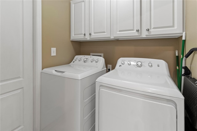 washroom featuring cabinet space and washing machine and clothes dryer