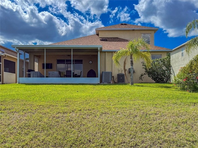 rear view of property with a sunroom, central AC unit, stucco siding, and a yard