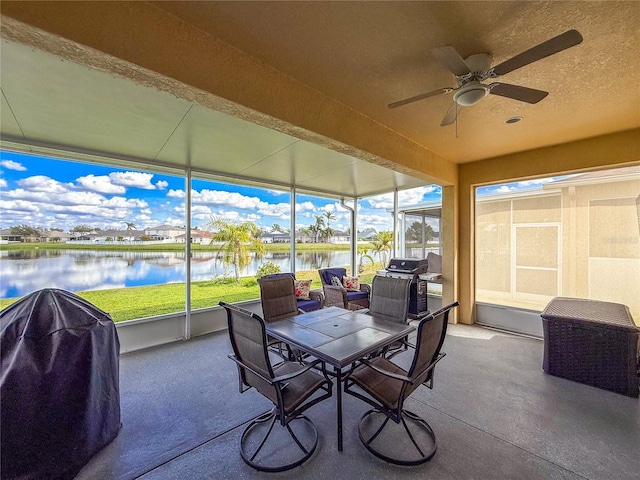 sunroom / solarium with a water view and a ceiling fan