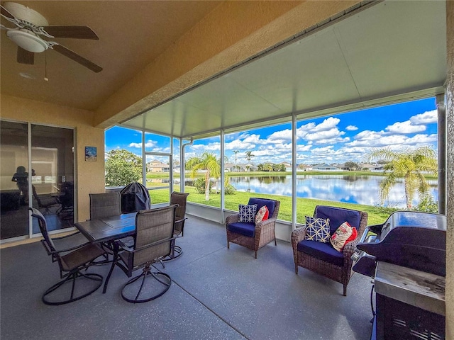 sunroom / solarium with a water view and ceiling fan