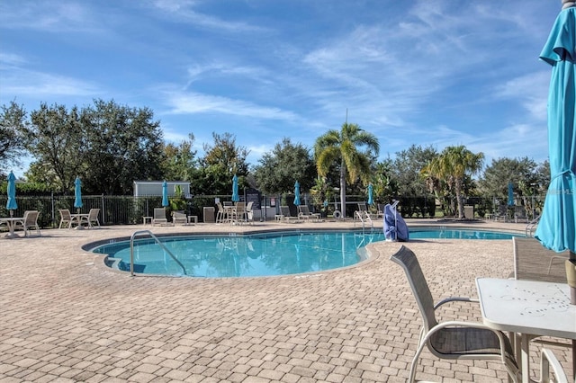 pool with a patio and fence