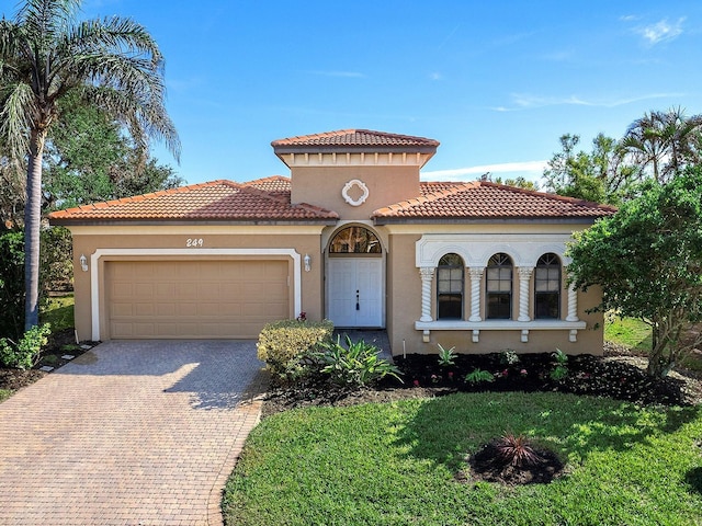 mediterranean / spanish-style house with a garage and a front yard