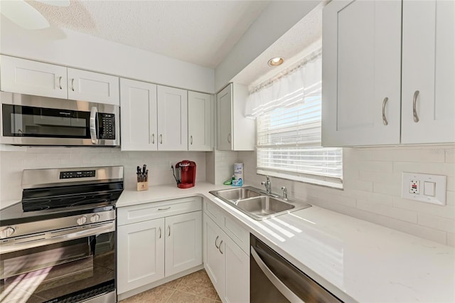 kitchen with white cabinetry, appliances with stainless steel finishes, sink, and decorative backsplash