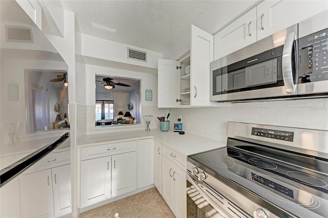 kitchen featuring white cabinetry, appliances with stainless steel finishes, a textured ceiling, and light tile patterned floors