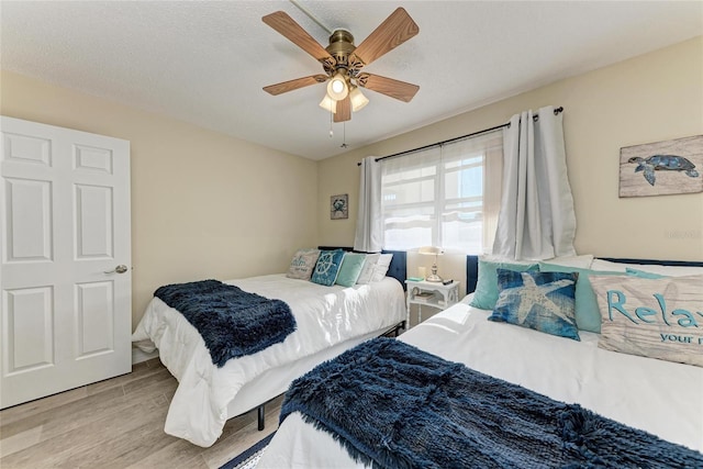 bedroom featuring a textured ceiling, ceiling fan, and light hardwood / wood-style flooring