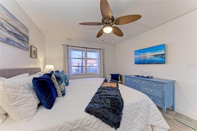 bedroom with ceiling fan, light hardwood / wood-style floors, and a textured ceiling