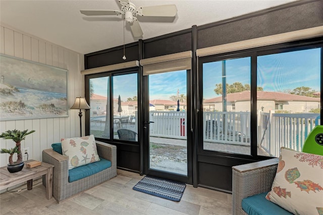 sunroom / solarium featuring ceiling fan