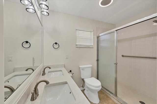 bathroom with tile patterned floors, toilet, a shower with door, and vanity