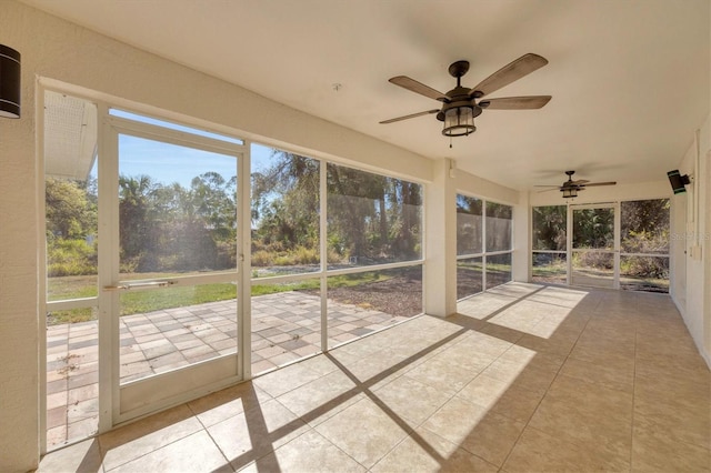 unfurnished sunroom with ceiling fan