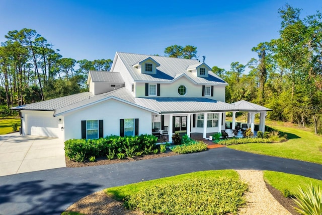 view of front of home with a garage, a front yard, and a porch