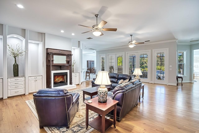 living room featuring french doors, ornamental molding, ceiling fan, and light hardwood / wood-style flooring