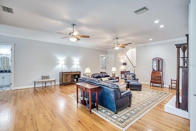 living room with crown molding, light hardwood / wood-style floors, and ceiling fan