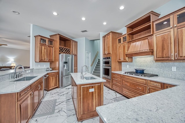 kitchen featuring stainless steel appliances, sink, an island with sink, and custom range hood