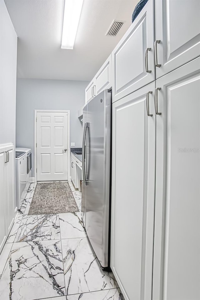 washroom with separate washer and dryer and cabinets