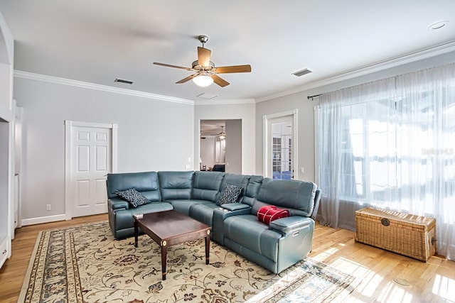 living room with light hardwood / wood-style flooring, ornamental molding, and ceiling fan