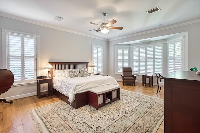 bedroom featuring multiple windows, light hardwood / wood-style flooring, and ornamental molding