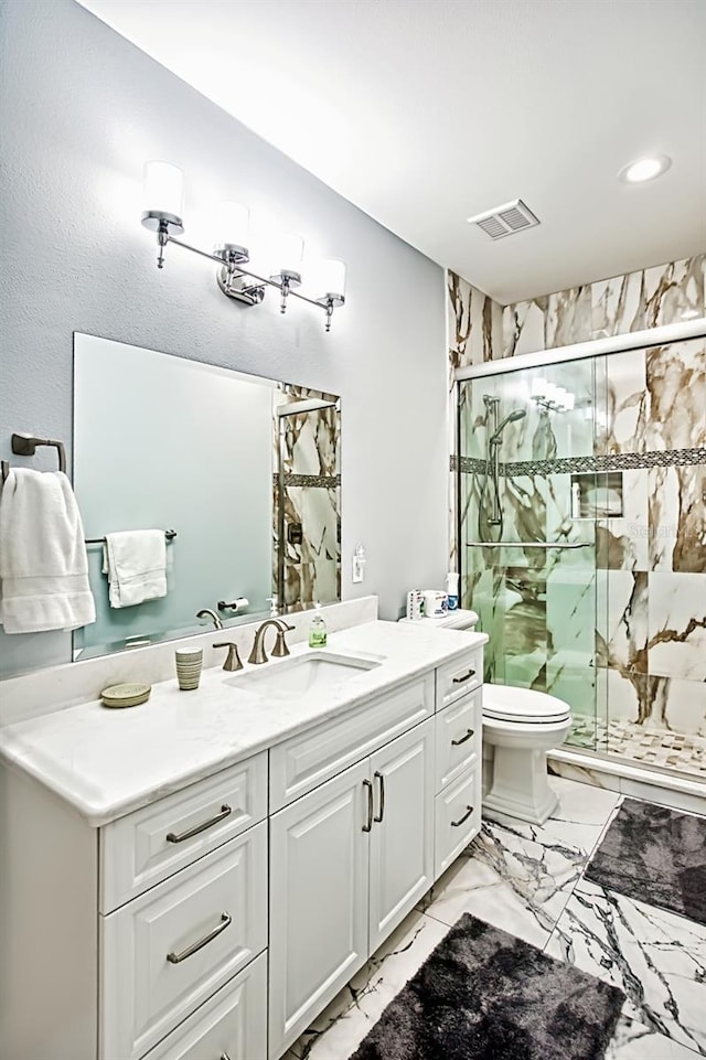 bathroom featuring vanity, a shower with door, and toilet