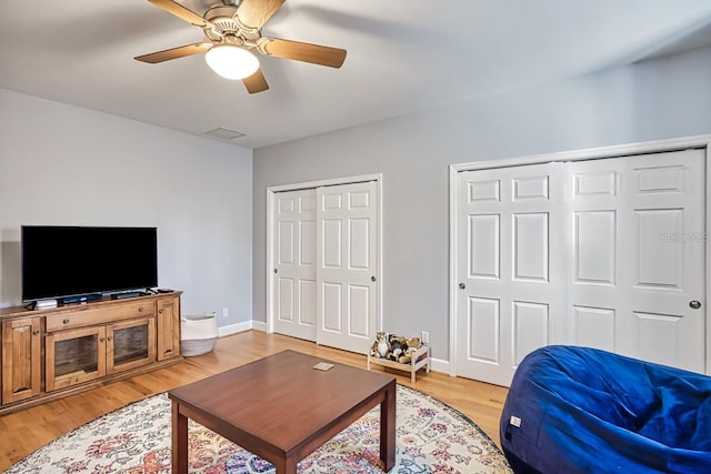 living room with ceiling fan and light wood-type flooring