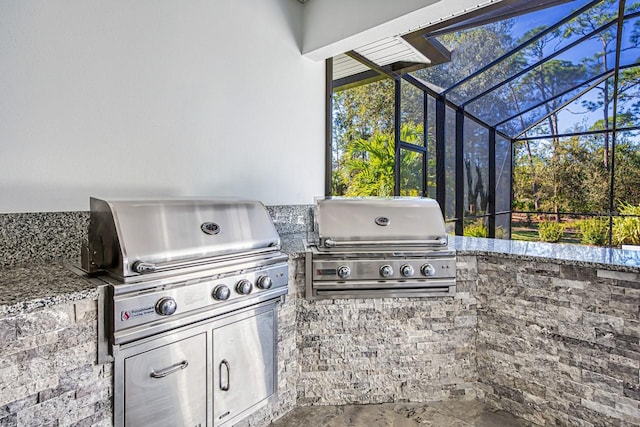 view of patio / terrace featuring a lanai, grilling area, and exterior kitchen