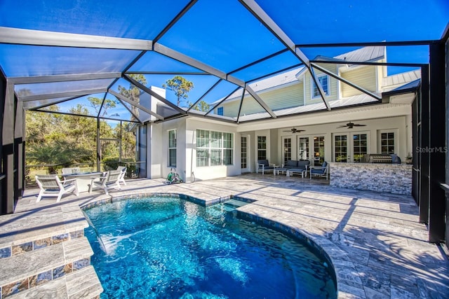 view of swimming pool featuring ceiling fan, a patio, outdoor lounge area, and glass enclosure