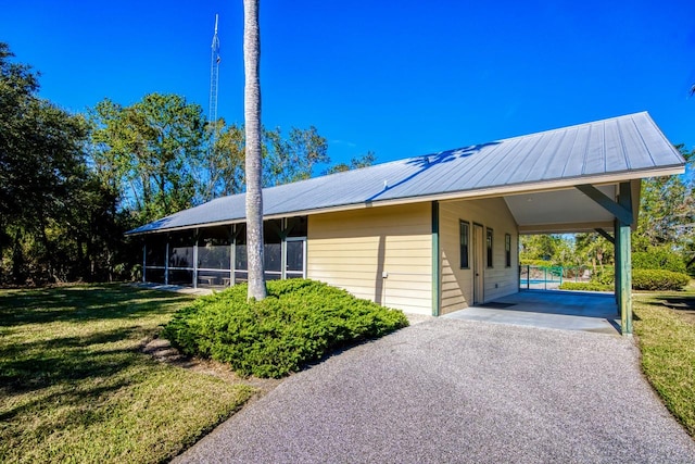 view of front of property with a front yard, a carport, and a sunroom