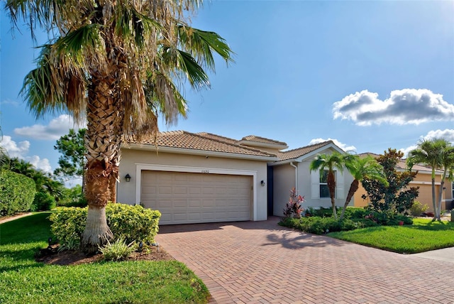 mediterranean / spanish-style house with a garage and a front yard