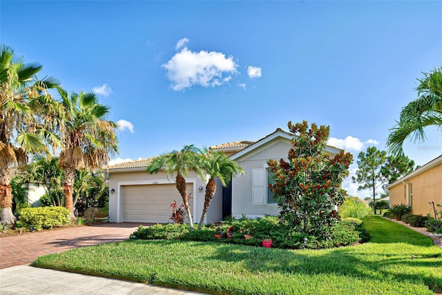 view of front of home with a garage and a front lawn