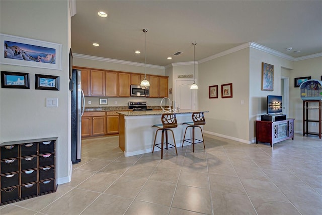 kitchen featuring hanging light fixtures, a center island with sink, stainless steel appliances, light stone counters, and a kitchen bar