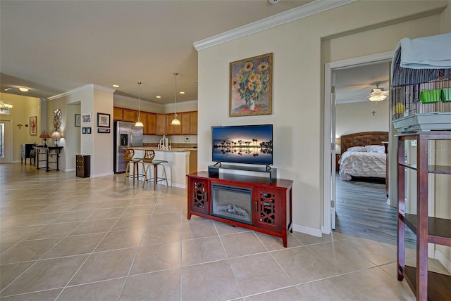 living room featuring crown molding, ceiling fan, and light tile patterned flooring