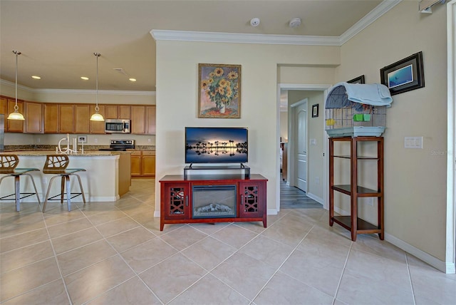 kitchen with appliances with stainless steel finishes, pendant lighting, a breakfast bar area, light tile patterned floors, and crown molding