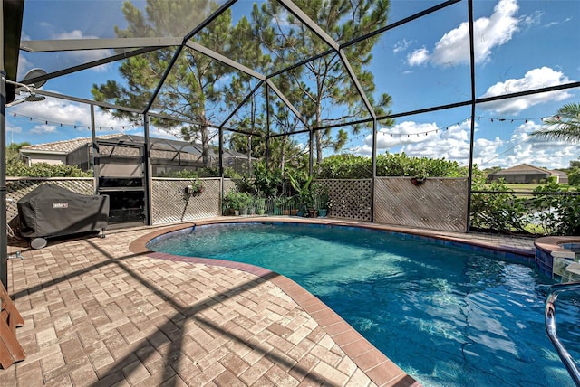 view of swimming pool with a grill, a lanai, and a patio area