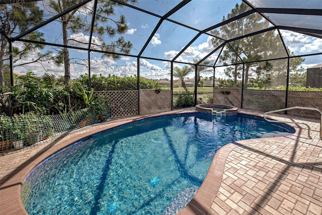 view of pool with an in ground hot tub, a patio area, and glass enclosure