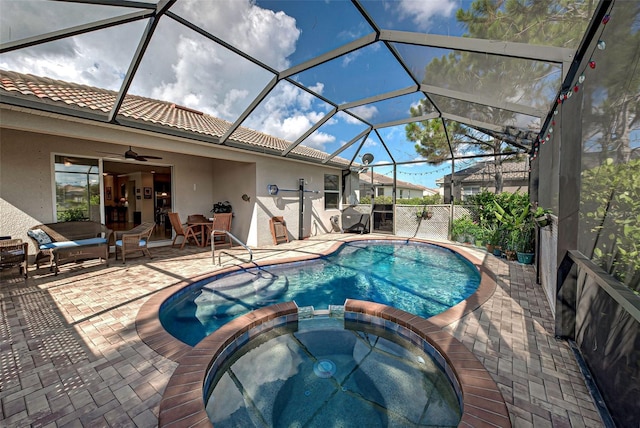 view of swimming pool with ceiling fan, a patio, glass enclosure, and an in ground hot tub