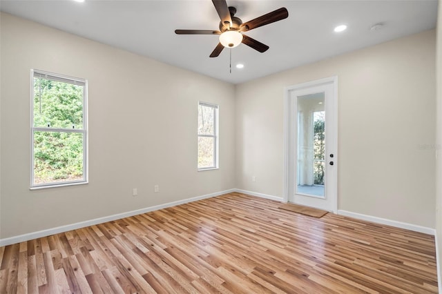 empty room featuring ceiling fan, a healthy amount of sunlight, and light wood-type flooring