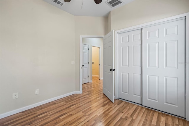 unfurnished bedroom featuring ceiling fan, light hardwood / wood-style floors, and a closet