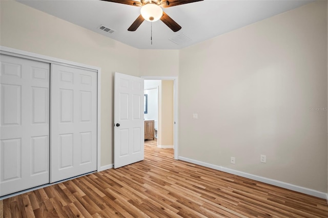 unfurnished bedroom with ceiling fan, light wood-type flooring, and a closet