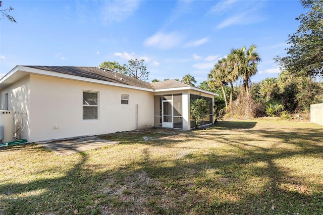 rear view of property featuring a sunroom and a lawn