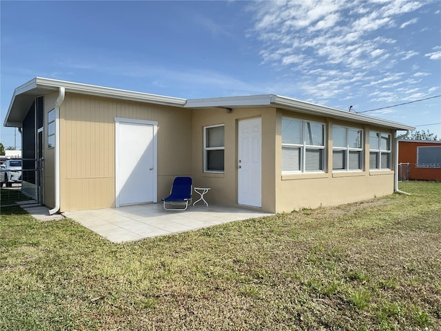 back of property featuring a yard and a patio