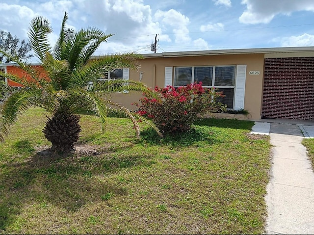 exterior space featuring a front yard and stucco siding