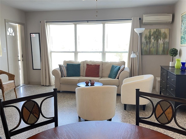 living area featuring a wall unit AC, plenty of natural light, and speckled floor