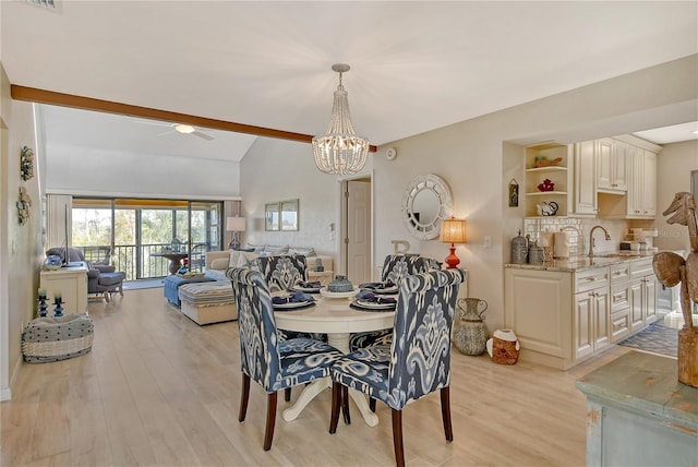 dining area featuring vaulted ceiling with beams, light wood-style flooring, and ceiling fan with notable chandelier