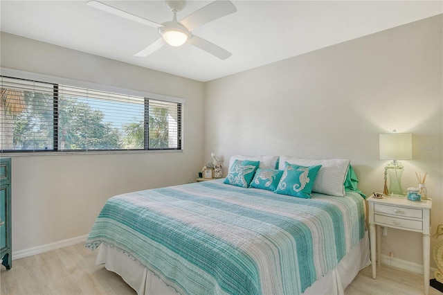 bedroom featuring a ceiling fan, baseboards, and wood finished floors