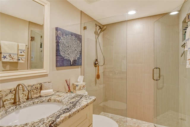 full bathroom featuring toilet, a shower stall, and vanity