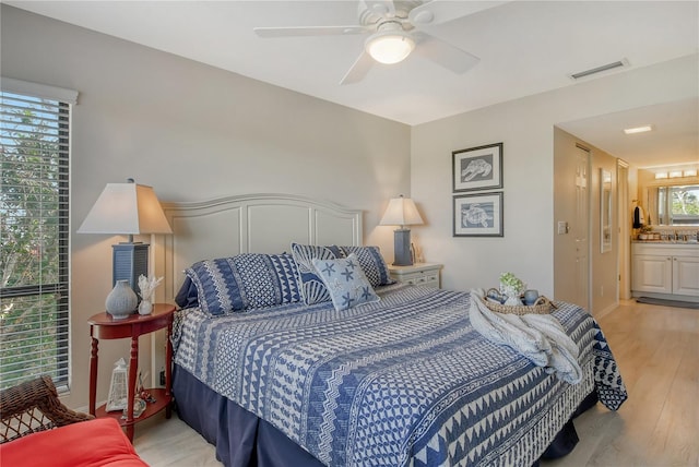 bedroom featuring visible vents, ceiling fan, light wood-style flooring, and a sink