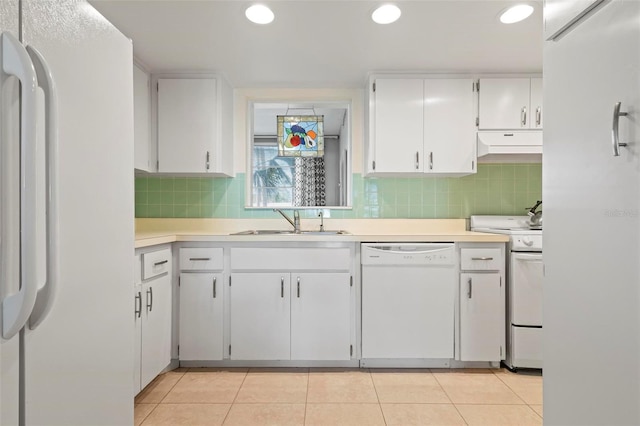 kitchen with sink, light tile patterned floors, white cabinets, and white appliances