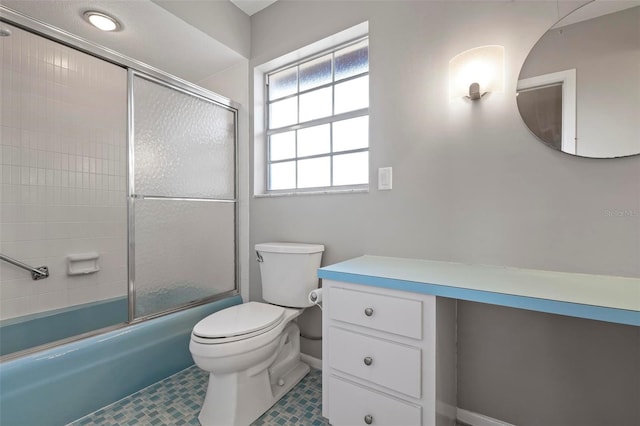 bathroom featuring tile patterned flooring, bath / shower combo with glass door, and toilet