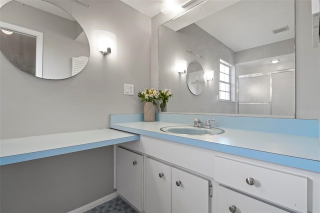 bathroom with vanity and a shower with shower door