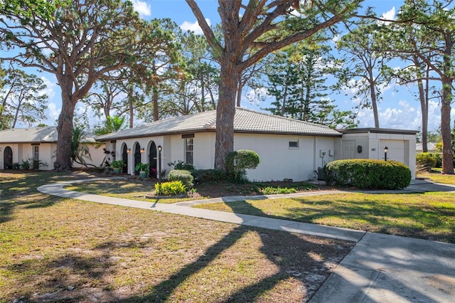 single story home featuring a garage and a front yard