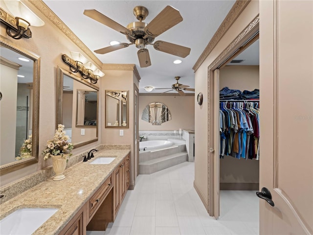 bathroom with double vanity, a garden tub, a spacious closet, and a sink