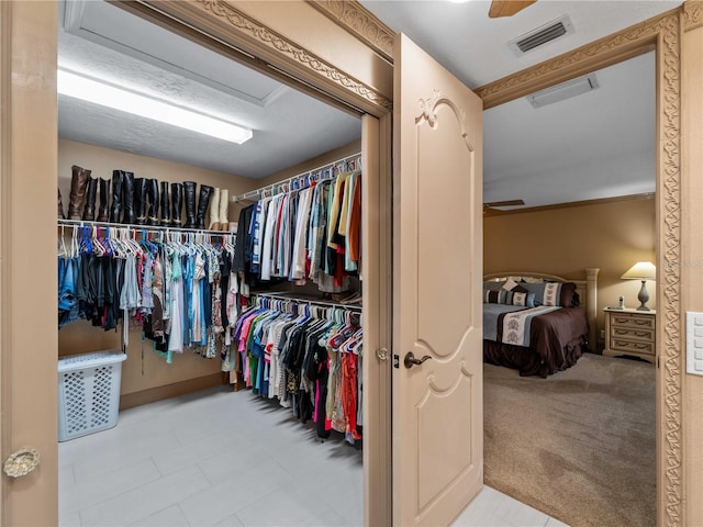 spacious closet with carpet, visible vents, and attic access